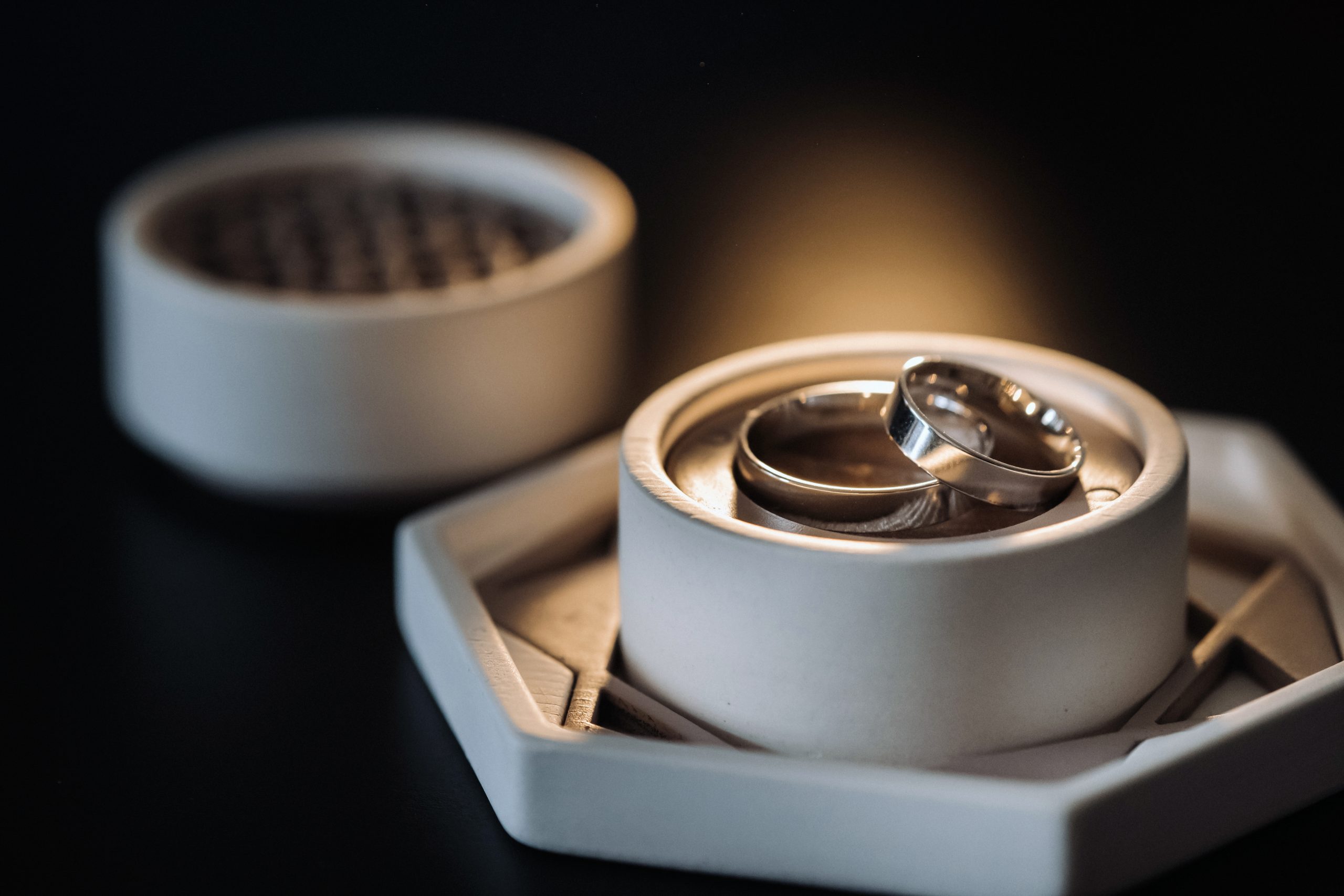 two gold wedding rings in a white box on a black background