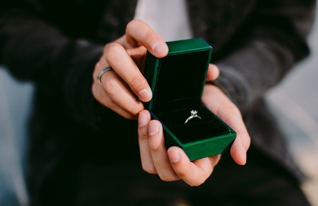 man holding ring box with engagement ring