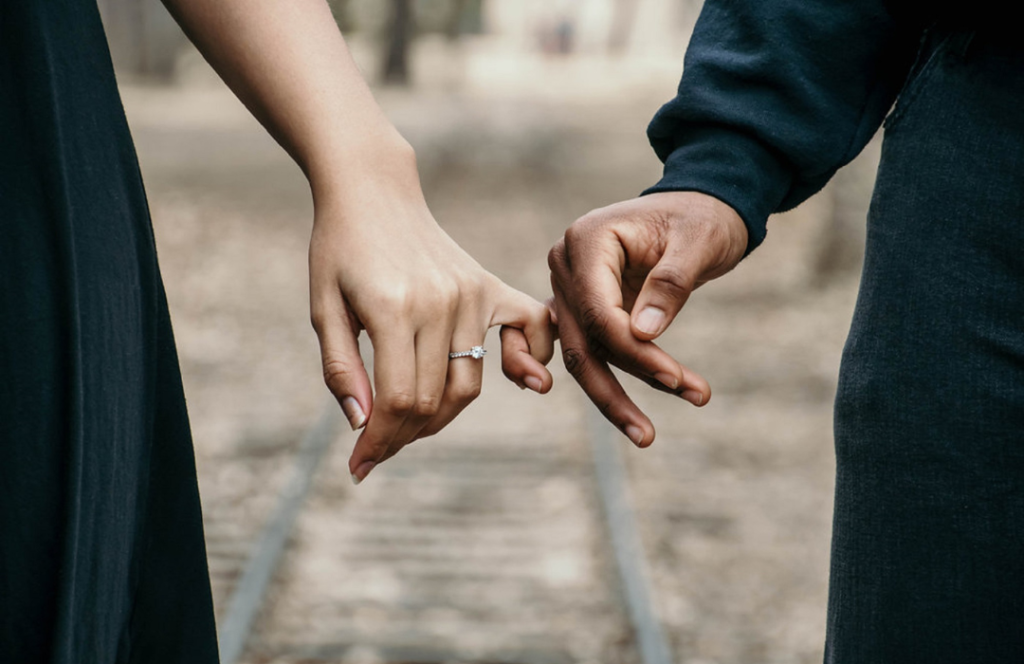 man and woman holding hands while wearing an engagement ring