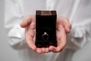 man holding engagement ring in a box