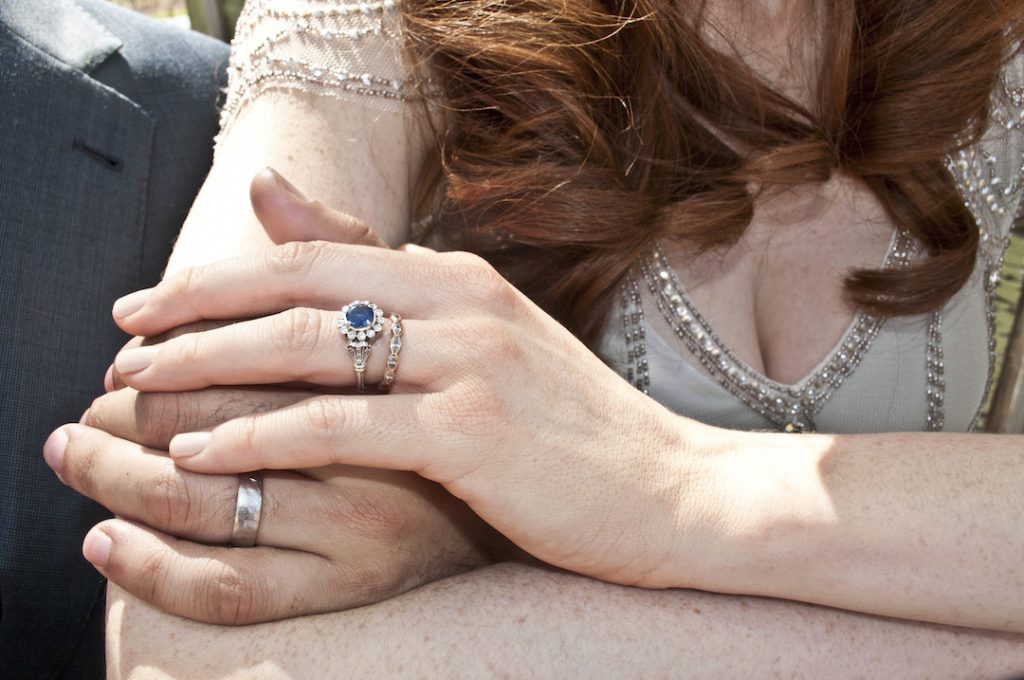 Bride and groom, holding hands, close-up, mid section