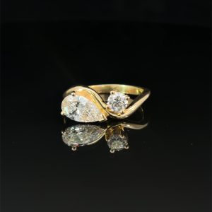 two stone diamond ring featuring pear cut and round diamond