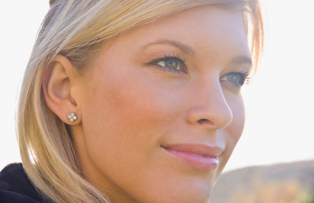 A blond female head shot wearing diamond earrings
