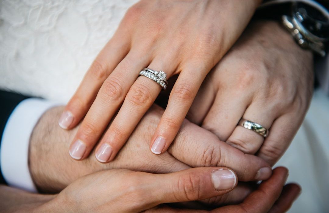 Close-up of an affectionate couple embracing, both wearing their engagement rings