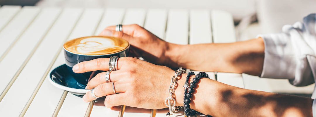 Cup of Coffee in woman hands wearing jewellery