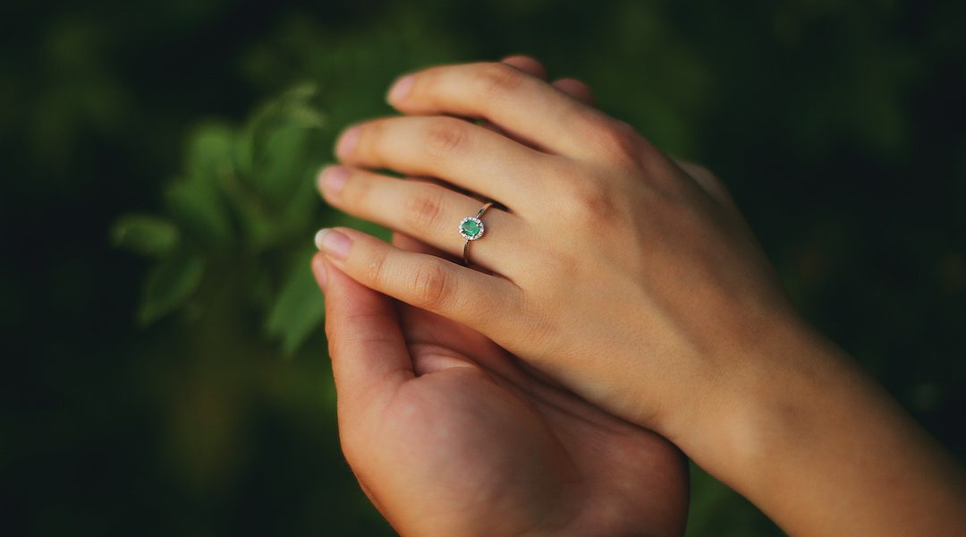 hands of a young couple with a ring. love, couple, relationship and holidays concept - close up of man giving diamond ring to woman