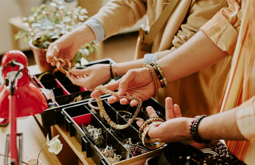 Close-up of hands choosing necklace and bracelets from display in jewelry shop showing intricate details and accessories being examined and selected with care
