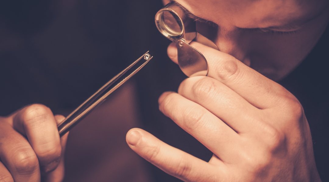 jeweller looking at a diamond through a loupe